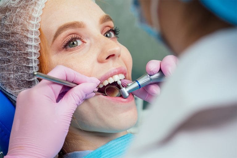 Beautuful redhaired ginger woman sits in the dental chair.She came to see the dentist in clinic.